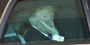 US-Präsident Trump sitzt in einem Auto und winkt