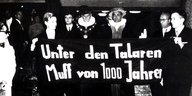 Schwarz-weiß Bild, auf dem Menschen ein Transpi halten. Auf diesem steht "Unter den Talaren Muff von 1000 Jahren"
