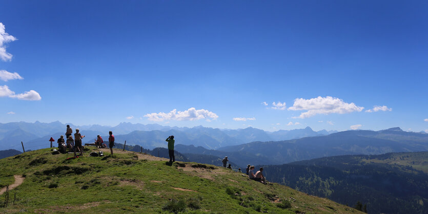 Alpenpanorama, Menschen auf dem Gipfel, weiter Blick auf andere Berge