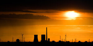 Aufgehende Sonne hinter einem Steinkohlekraftwerk
