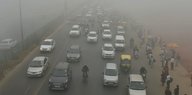 Autos, Mopeds und Rikschas im Smog von Delhi