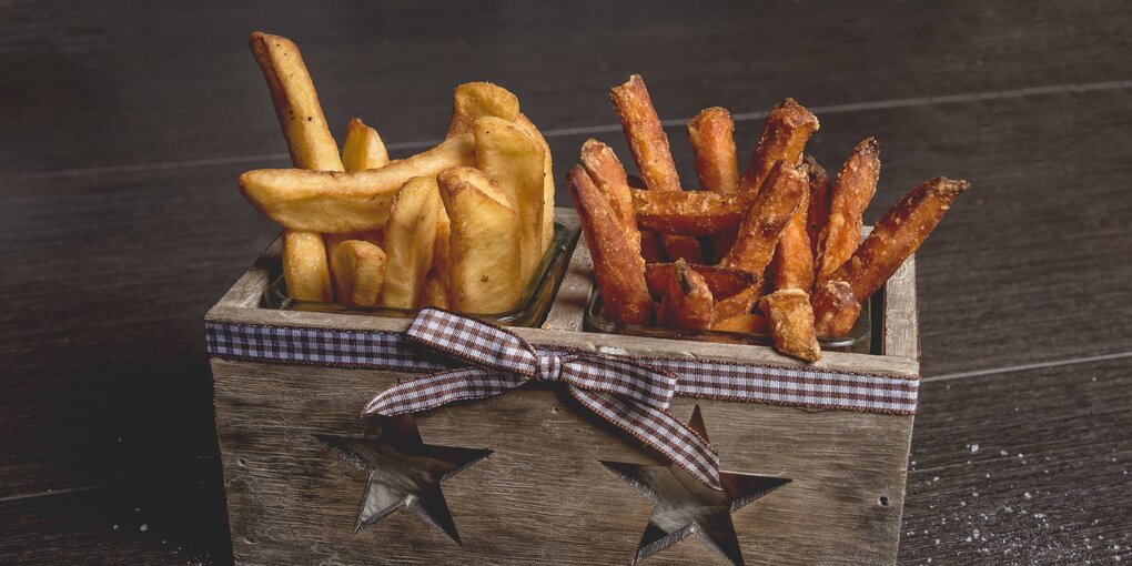 Frau mit einem Teller Süßkartoffelpommes