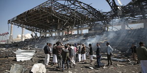 Männer stehen vor einem völlig zerstörten Bauwerk