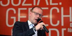 Matthias Höhn mit einem Mikrofon in der Hand