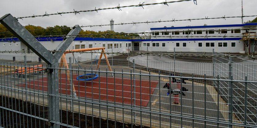 Blick auf Wohncontainer durch Stacheldraht