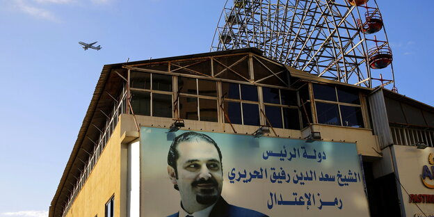 Ein Plakat mit Libamons Ex-Regierungschef Hariri an einer Hauswand, dahinter ein Riesenrad