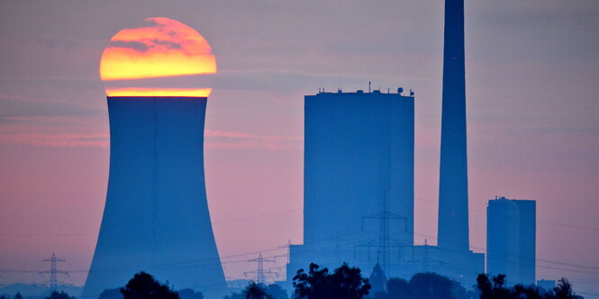 die Sonne geht hinter einem Kühlturm auf