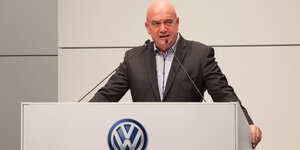 Bernd Osterloh steht hinter einem Rednerpult, auf dem das VW-Logo prangt