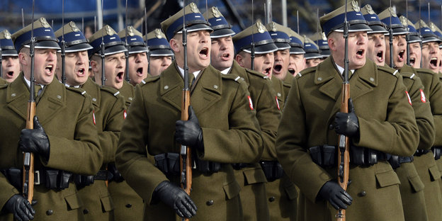 Soldaten, die Gewehre in den Händen halten, stehen in Reihen angeordnet und brüllen