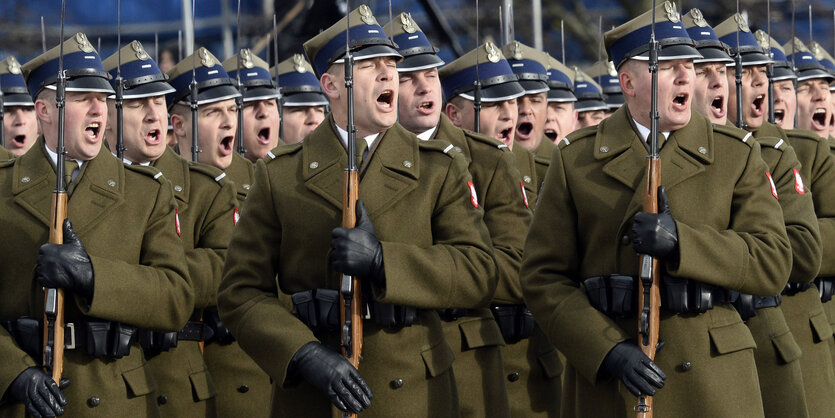 Soldaten, die Gewehre in den Händen halten, stehen in Reihen angeordnet und brüllen