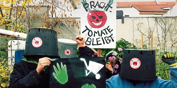 Menschen mit Pflanzenkübeln über dem Kopf und einem Plakat auf welchem steht: "Prachttomate bleibt"