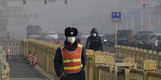 Zwei Menschen mit Atemschutzmasken auf einer Straße