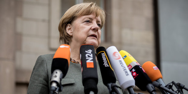 Angela Merkel steht vor Mikrofonen