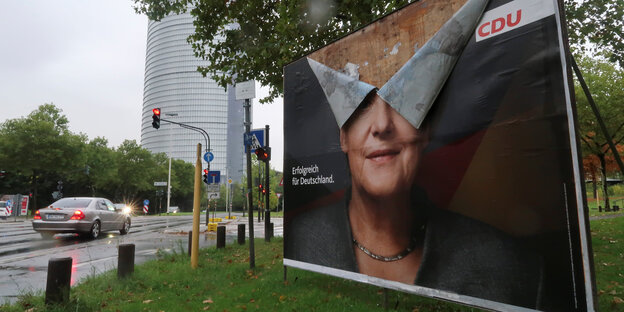 ein Wahlplakat mit Merkel-Kopf - stark beschädigt
