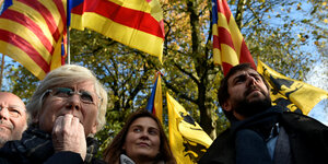 Menschen stehen zusammen und halten die Fahne Kataloniens