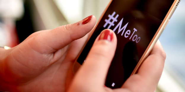 Hände halten ein Smartphone, auf dem #MeToo" steht