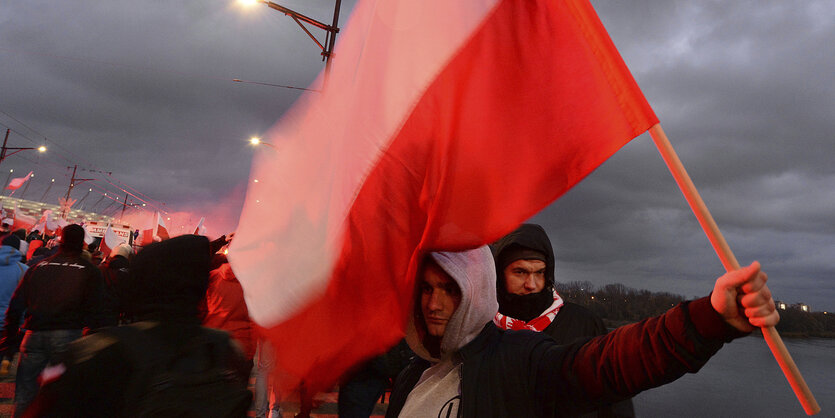 Menschen in einer Menschenmenge tragen eine Flagge