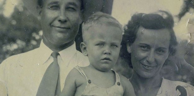 Schwarz-Weiß-Bild zweier Menschen, die ihr Kind im Arm halten