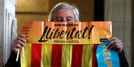 Mann hält untere Gesichtspartie mit Katalonienfahne bedeckt