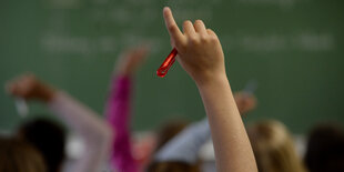 Schüler und Schülerinnen melden sich in einem Klassenraum.