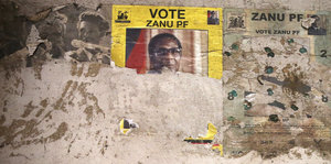 Ein halb abgerissenes Wahlplakat an einer Wand