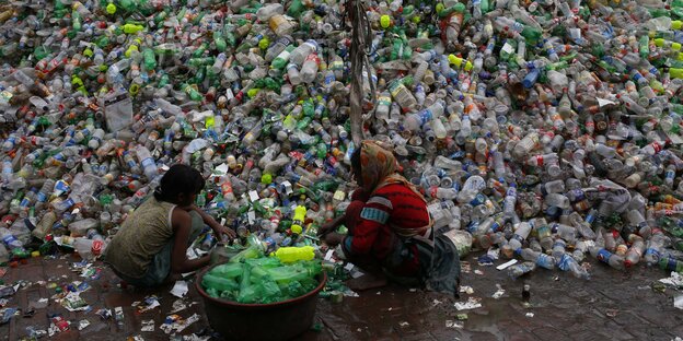Zwei Mädchen sortieren Plastikflaschen