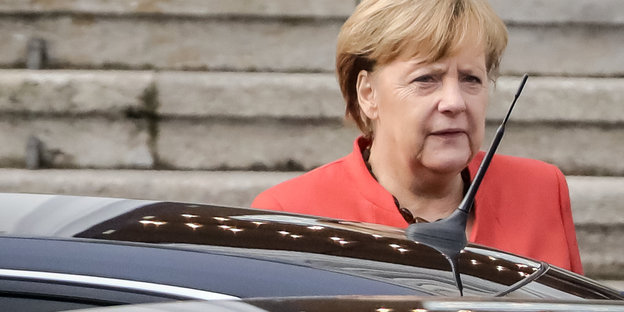 Angela Merkel hinter einem Auto