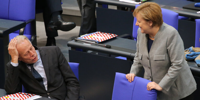 Jürgen Trittin (li., sitzend) und Angela Merkel sprechen miteinander im Bundestag