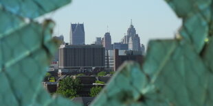 Eine Stadt gesehen durch ein zerbrochenes grünes Fenster