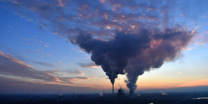 Am Abendhimmel breiten sich die Dampfwolken eines Kohlekraftwerks aus