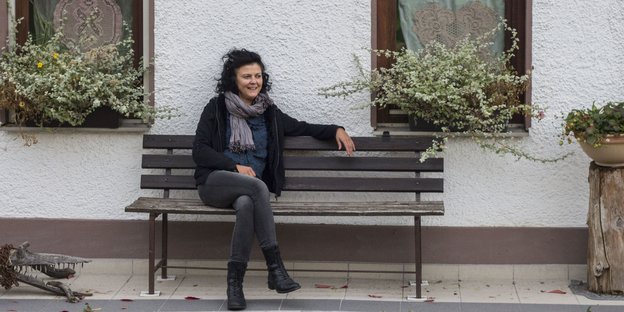 Irmgard Kolbe sitzt auf einer Bank vor ihrem Haus