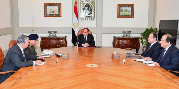 Männer sitzen um einen Tisch, darunter auch der ägyptische Präsident