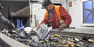 Zwei Männe am Fließband sortieren Müll