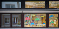 Auf einem Fenster eine Schule gemalte Regenschirme