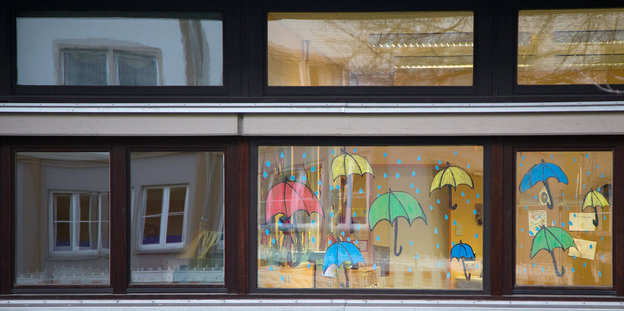 Auf einem Fenster eine Schule gemalte Regenschirme
