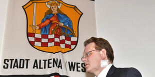 Ein Mann, Andreas Hollstein, unter dem Stadtwappen von Altena