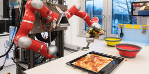 Ein Roboter belegt Pizza