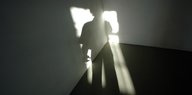 Schatten einer Person fällt durch das Fenster in ein leeres Zimmer