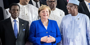 Merkel steht in einer Gruppe von Menschen