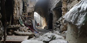 in Frau geht durch die Zerstörungen der Altstadt von Aleppo, Syrien, am 19.01.2017.