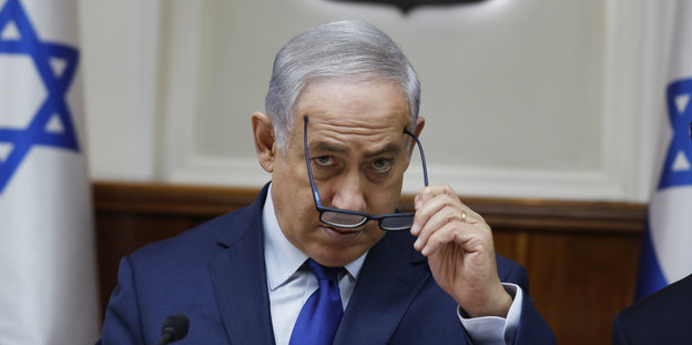 Benjamin Netanjahu nimmt seine Brille ab