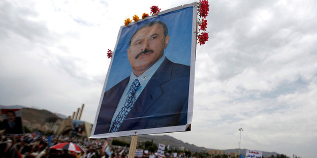 Vor einer Menschenmasse wird ein Plakat mit dem Porträt des ehemaligen jemenitischen Präsidenten Ali Abdullah Saleh hochgehalten.