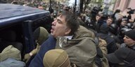 Michail Saakaschwili, wie er bei seiner Festnahme in ein Auto gedrückt wird