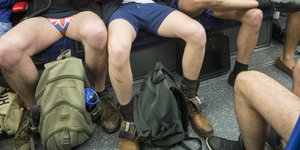Unterkörper breitbeinig sitzender Männer in Unterhosen