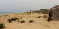Hütten stehen an einem Sanstrand direkt am Meer