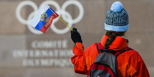 Eine Frau mit Wollmütze schwenkt eine russische Flagge