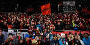 Viele Menschen tragen rote Schals und schwingen rote Fahnen des Östersunds FK