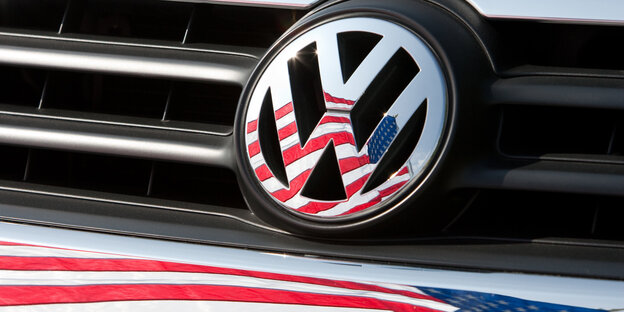 Auf einer Kühlerhaube prangt ein VW-Symbol, in dem sich die USA-Fahne spiegelt