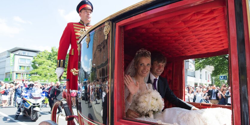 Ein Hochzeitspaar in einer Kutsche