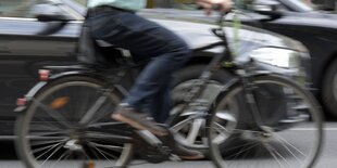 Nahaufnahme Radfahrer und Auto nebeneinander in Bewegung